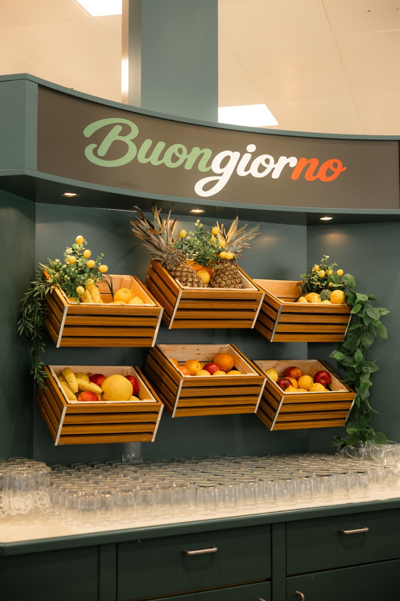 Holzkisten mit frischem Obst an der Buongiorno-Wand